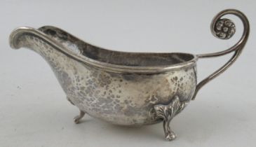 A George V Arts and Crafts silver sauce boat, with hammered decoration and scroll handle, Birmingham