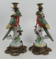 A pair of modern candlesticks, in porcelain and gilt metal, modelled as parrots in a tree, height