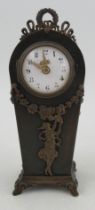 A metal cased mantel clock, with white enamel dial, the case applied with gilt metal sways and