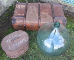 A glass carboy, trunk and hat box