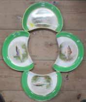 A set of four Soho Pottery crescent dishes, decorated with fish