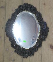 An oval mirror, with pressed metal laid on wood frame, total height 20ins, width 15ins