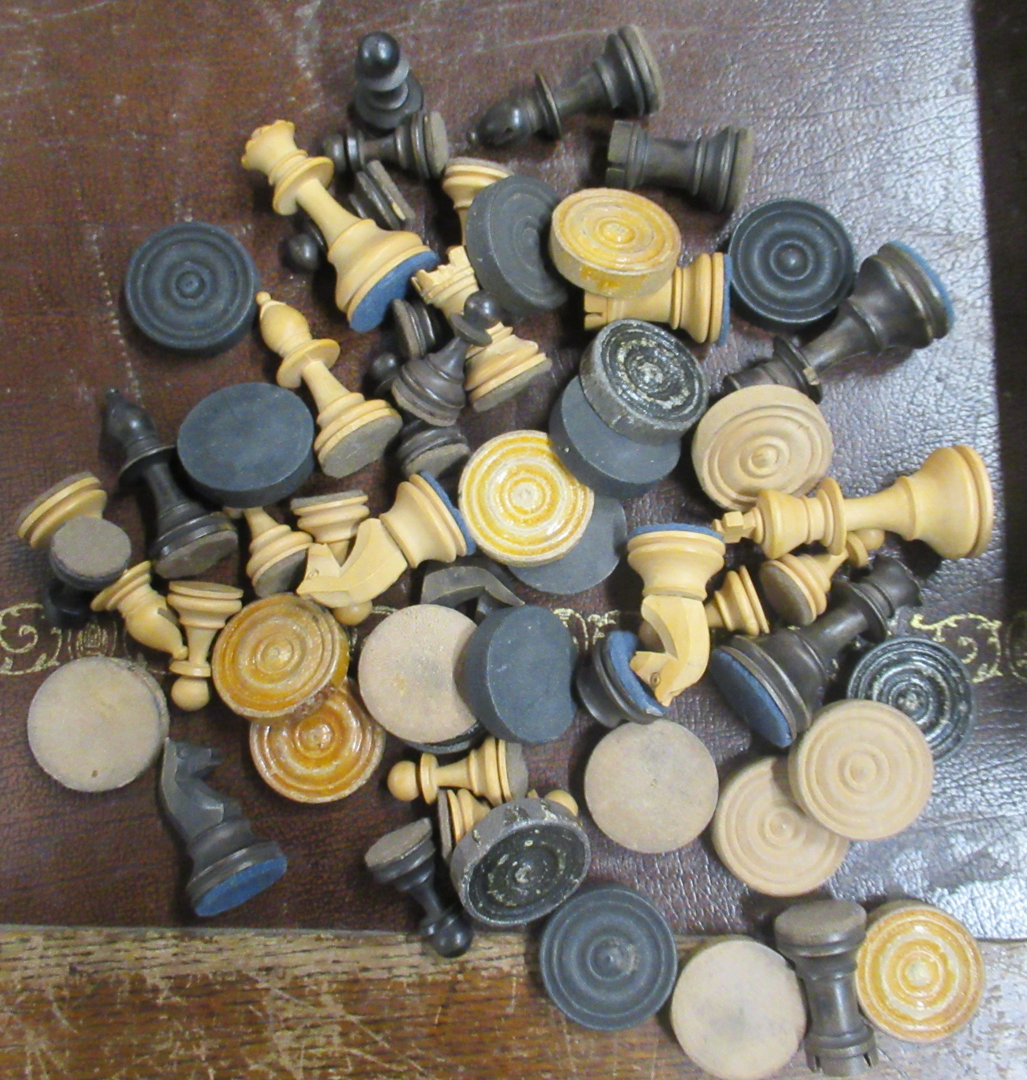 A collection of wooden chess and draughts pieces