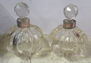 A pair of glass scent bottles, with silver collars