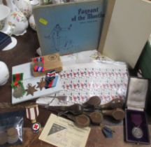 A collection of items, to include two books, a embroidered table cloth, war time service medals,