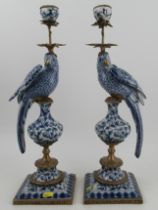 A pair of modern candlesticks, in porcelain and gilt metal, modelled as parrots on columns,