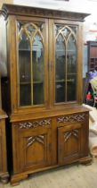 A Gothic style oak glazed display cabinet, with carved decoration, width 43ins, height 84ins
