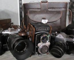 An Olympus camera, together with other cameras and accessories