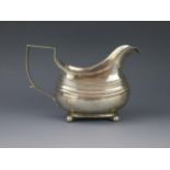 A George III silver cream jug, maker's mark worn, London, 1812, crested, of barge-shaped outline,