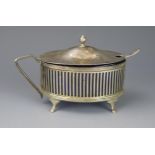 A George V silver mustard pot and cover, maker Harold Bushell & Co Ltd, Birmingham, 1912, of oval