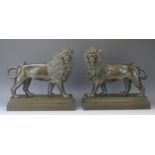 A pair of late 19th/early 20th century bronze lions, raised on all fours with turned heads,