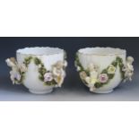 A pair of late 19th Century Sitzendorf cache pots, decorated with swags of roses and cherubs,