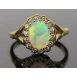 White Opal and Diamond Cluster Ring in an 18ct hallmarked gold setting, 9x7mm central stone, 13x11mm