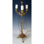 A late 19th century gilt metal, three branch table lamp, with floral decorated urn-shaped sconces on