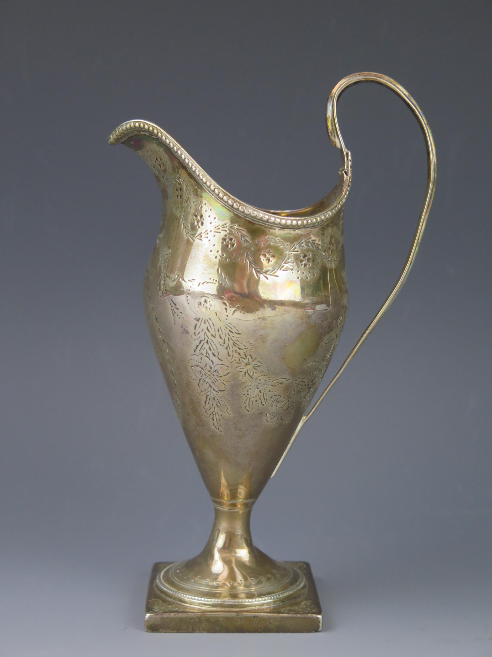 A George III silver cream jug, maker's mark worn, London, 1786, monogrammed, of helmet-shaped