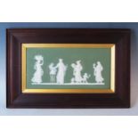 A Wedgwood Jasperware plaque, decorated with neo-classical maidens to a green ground, contained in a
