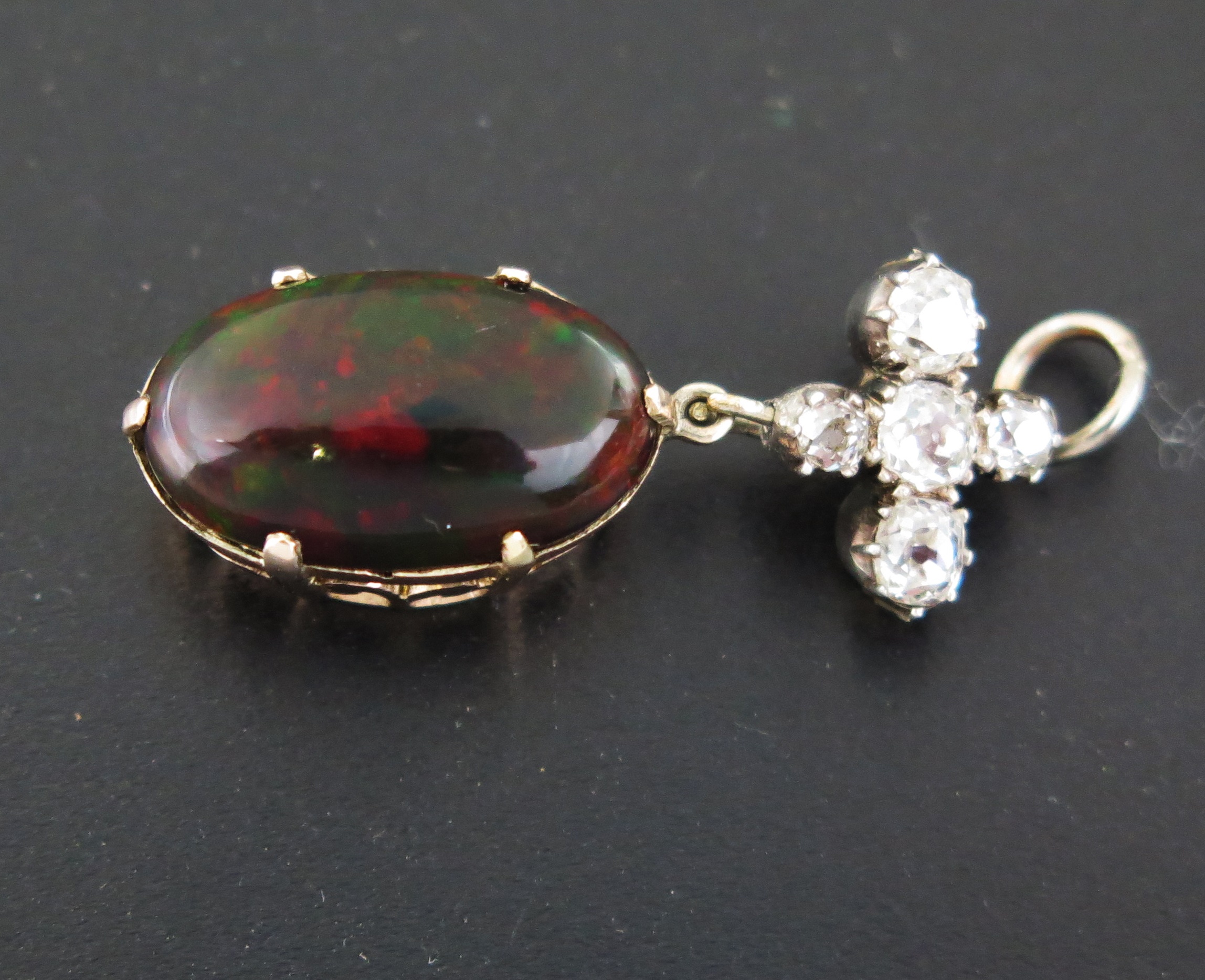 An Opal and Diamond Pendant, the diamond cross suspension above an oval opal 16x10mm