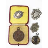 Four silver sporting medallions, various makers and dates together with a cased bronze Life Saving