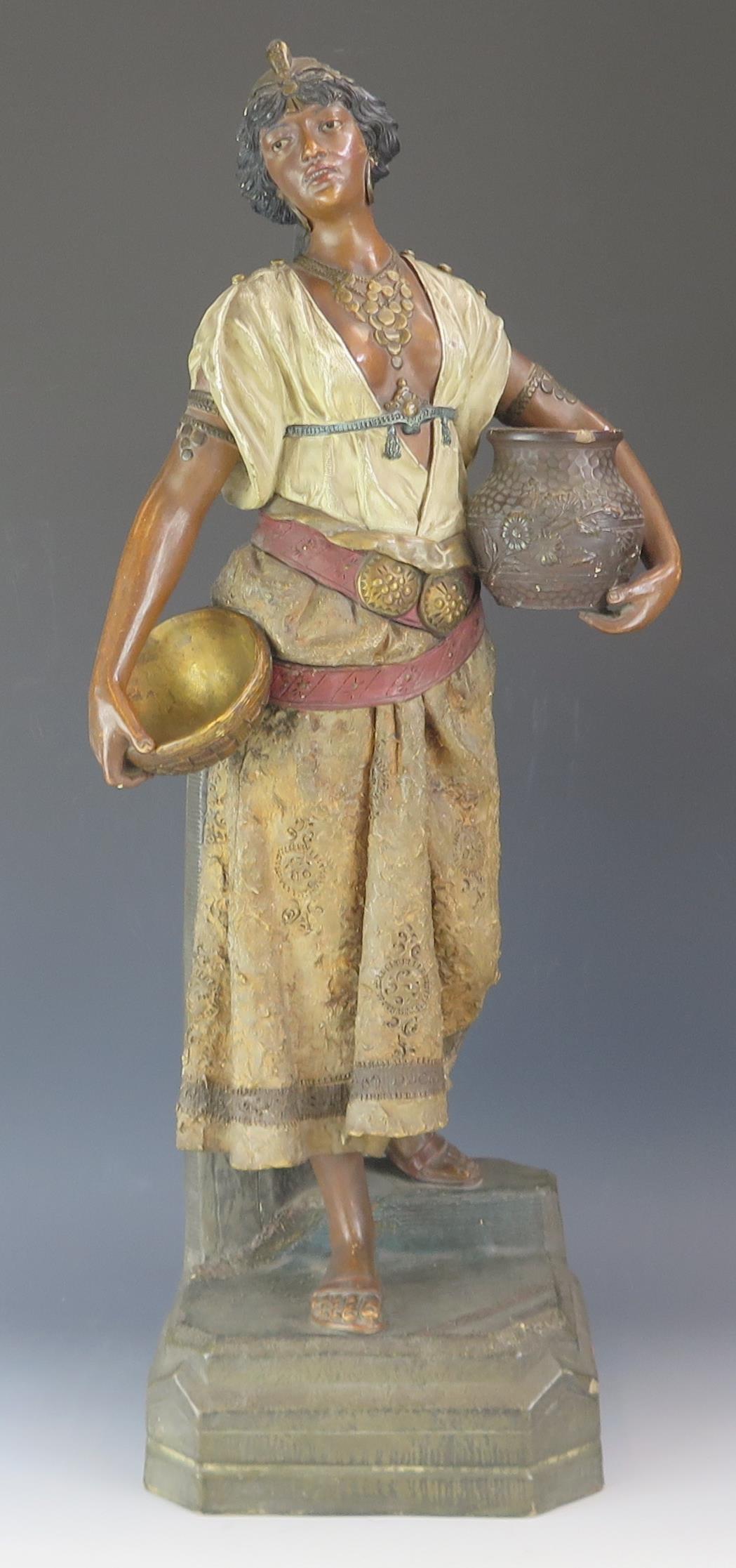 A late 19th century terracotta figure of a Nubian female water bearer, with polychrome decoration,