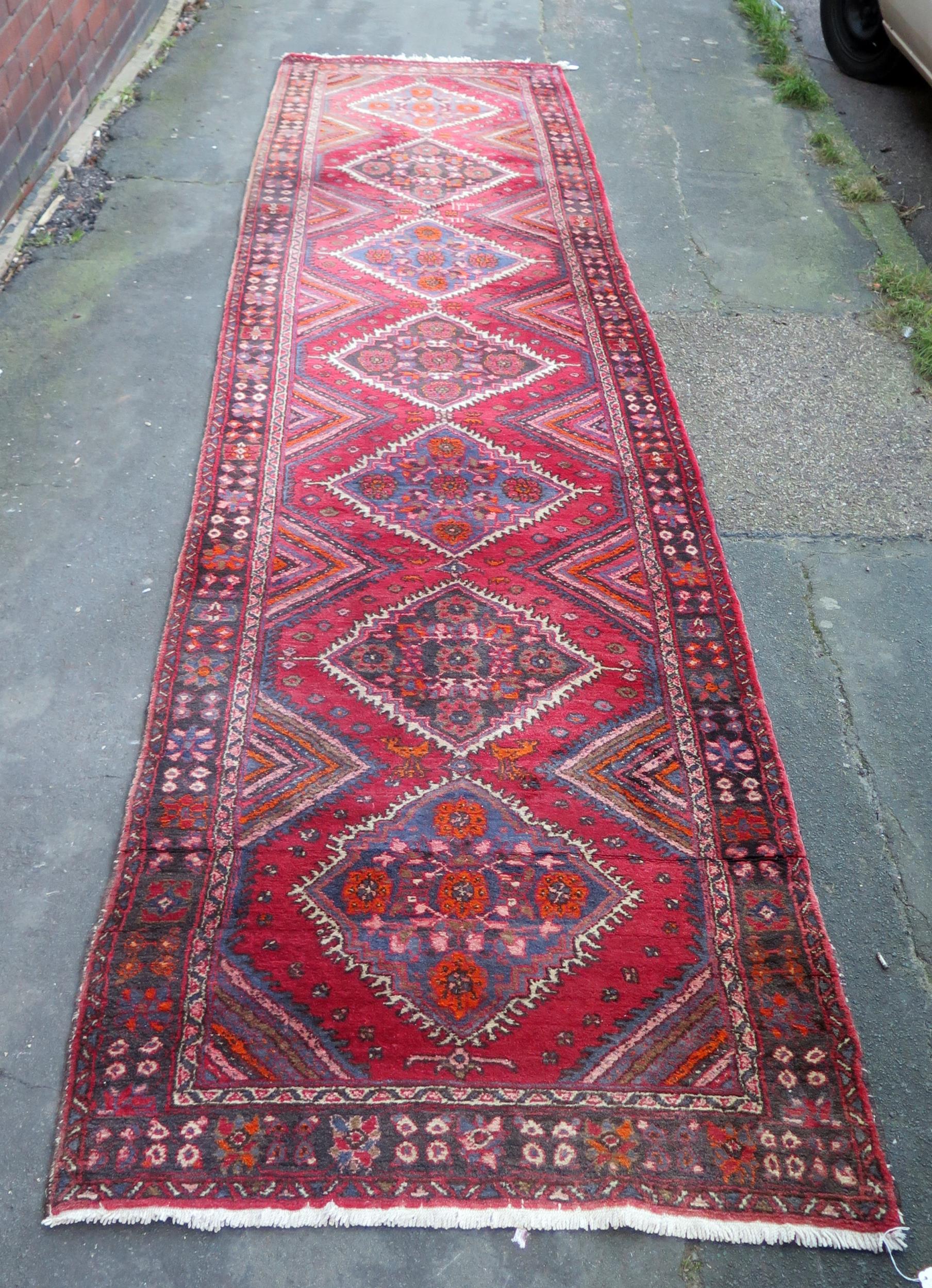 A large 20th Century Turkish Runner, wool carpet, geometric diamond lozenges, red ground, pyramid
