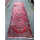 A large 20th Century Turkish Runner, wool carpet, geometric diamond lozenges, red ground, pyramid