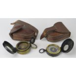 Two army style compasses contained in stitched leather cases.