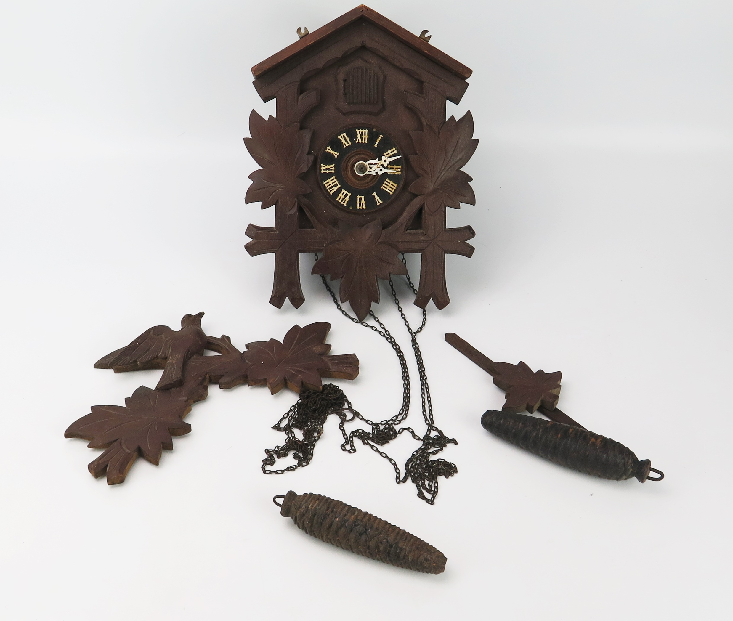 A late 20th century Swiss style cuckoo clock of traditional design, with pine cone-shaped weights.