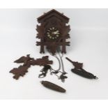 A late 20th century Swiss style cuckoo clock of traditional design, with pine cone-shaped weights.