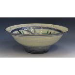 A studio pottery fruit bowl, of circular outline, decorated with birds flying over an olive bush, to