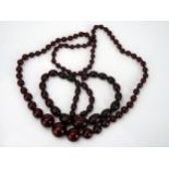 Two Faux Cherry Amber Bead necklaces, one 29" (74cm) with round beads (largest bead 24mm, 39.4g) and