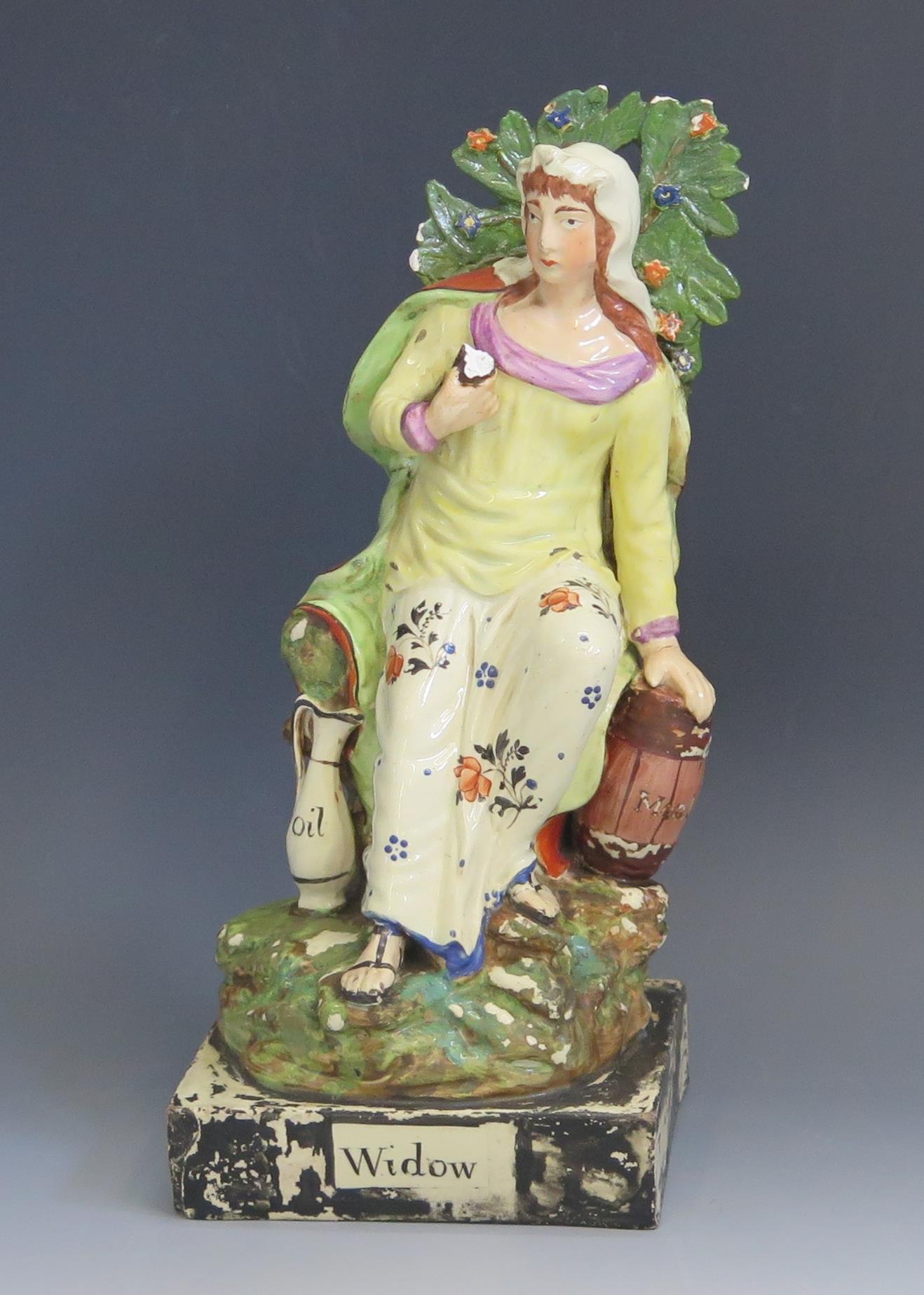A Staffordshire pottery pearlware figure 'Widow' 26cm high. Chips to the foliage and loss of