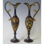 A pair of Iron and gilt decorated ewers, of slender baluster form, with scroll handles, having