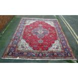 A 20th Century Kashan style wool carpet, blue central medallion, red field, cream spandrels, blue