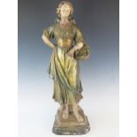 A large late 19th century French terracotta figure of a female fish seller, wearing a head scarf and