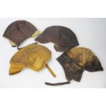 Four various brown leather flying helmets.