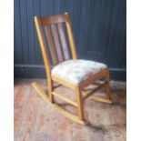 A light oak rocking chair, with slatted back and slip in swept, on swept rockers.