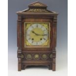 An oak cased mantel clock of architectural outline, with 16cm square brass dial and silvered Roman