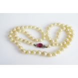 A Graduated Akoya Pearl Necklet with a synthetic ruby and diamond clasp, 55cm. Sold with SafeGuard