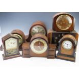 Seven assorted mantel clocks and clock cases, most of arched outline all incomplete and in need of
