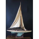 An early 20th century pond yacht, with two-tone painted hull, simulated planked deck, cloth sails,