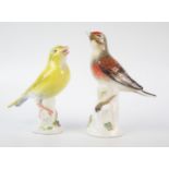 Two Meissen porcelain finches, perched on tree stumps, 13cm and 12 cm high. Both with damaged beaks.