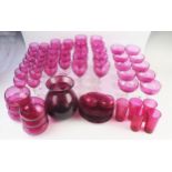 A Part suite of cranberry glass drinking vessels, including ten champagne glasses, ten wine glasses,