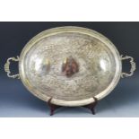 An Indian silver serving tray, of oval outline, with decorative cartouches of figures and animals in