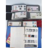 A collection of British and world stamps, mostly British First Day Covers, contained in albums, some