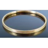 A 9ct Gold Bangle with engine turned decoration, 76mm internal diameter, 7.1g