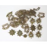 A collection of Devon Cadet brass shoulder badges, and Devonshire Regiment cap badges.