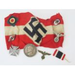 A Third Reich period armband, a silver Maltese cross brooch/pendant, coin brooch, and other badges.