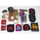 A collection of WWII period militaria including War and Defence Medals, cloth badges, pay book,