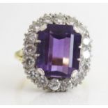 An Amethyst and Diamond Cluster Ring, the 12.5x10mm emerald cut central stone in and 18ct gold
