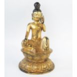 A Chinese gilded bronze figure of a seated Buddha, with raised left and, seated on a lotus flower,